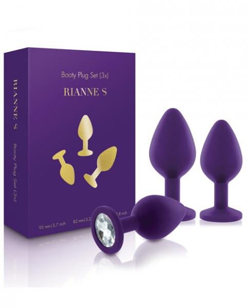 A purple box labeled "Rianne S Booty Plug Set 3X Purple" is shown beside three purple silicone butt plugs of different sizes—an ideal kit for exploring erogenous zones, with one plug featuring a jeweled base.